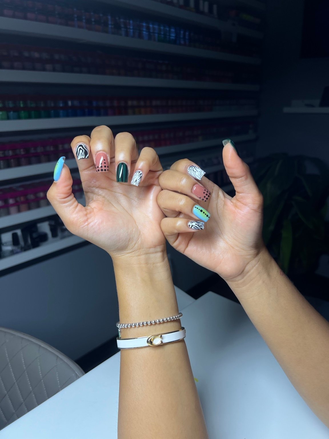 Multicoloured hand-painted nail art across both hands