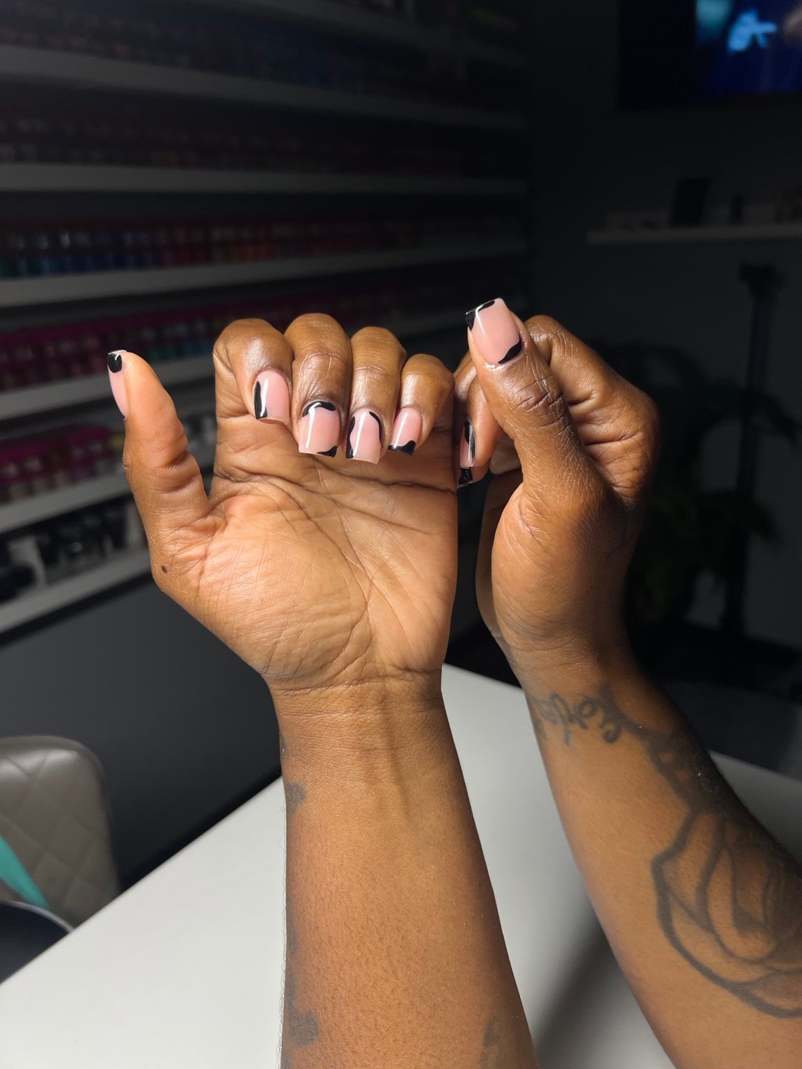 Pink nails with black accent tips on both hands